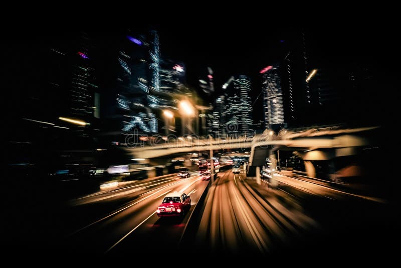 Moving through modern city street with illuminated skyscrapers. Hong Kong. Abstract cityscape traffic background with taxi car driving at night. Motion blur, art toning. Moving through modern city street with illuminated skyscrapers. Hong Kong. Abstract cityscape traffic background with taxi car driving at night. Motion blur, art toning