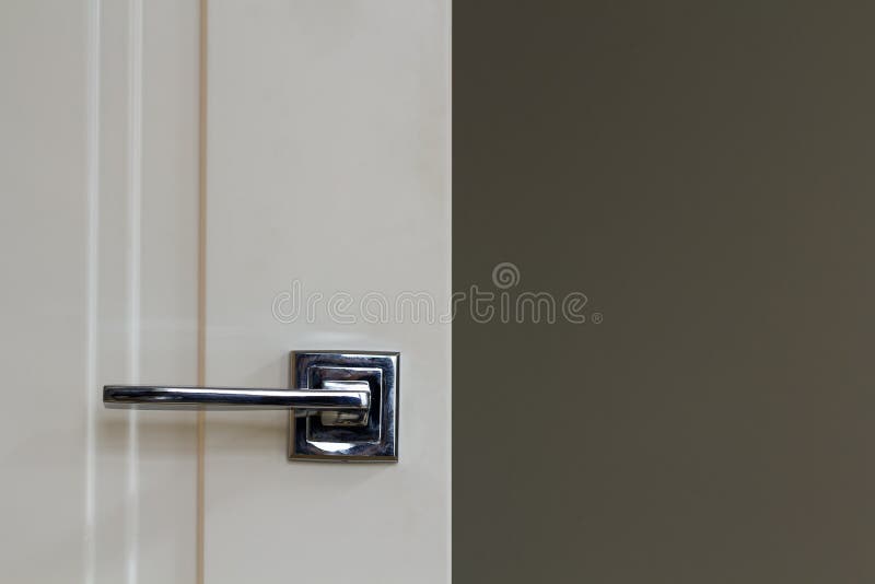 Modern Stainless Steel Door Handle on White Wooden Doors Stock Image