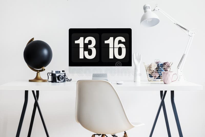Modern stol vid ett industriellt skrivbord med en datorskärm, filmkameran och garneringar i en hipsterstudie gör mellanslag inre arkivbild Modern stol vid ett industriellt skrivbord med en datorskärm, filmkameran och garneringar i en hipsterstudie gör mellanslag inre arkivbild