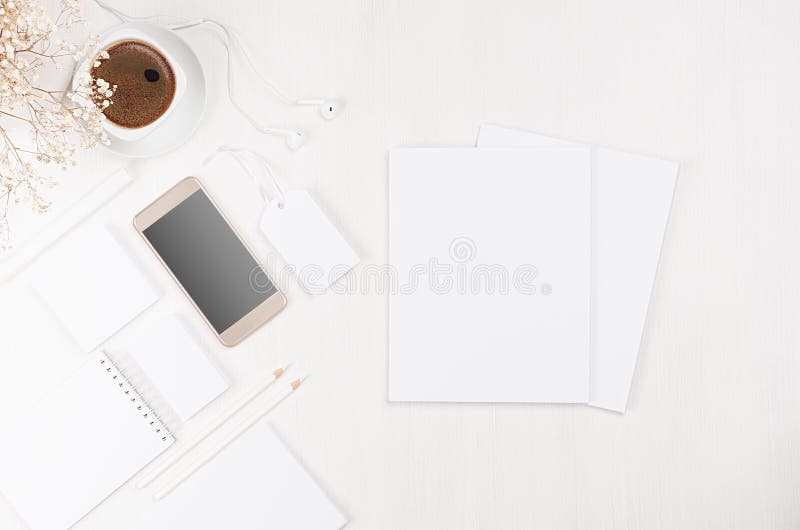 Modern stylish working place with blank white stationery, brochure, phone, coffee, flowers on soft white wood board. stock photos Modern stylish working place with blank white stationery, brochure, phone, coffee, flowers on soft white wood board. stock photos