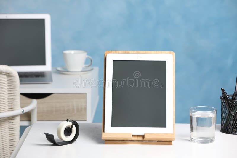 Modern Tablet, Glass of Water and Stationery on White Desk Stock Image