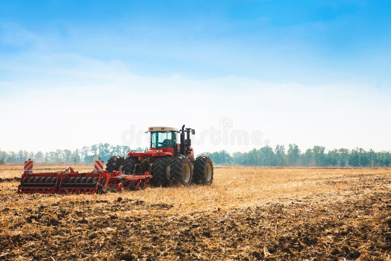 Modern tractor in the field with complex for the plowing of soil. stock image