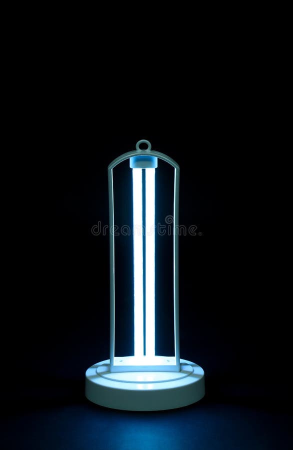 Modern ultraviolet lamp glowing on black background