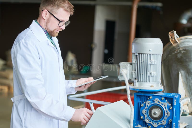 Modern ung arbetare på fabriken royaltyfri bild Modern ung arbetare på fabriken royaltyfri bild