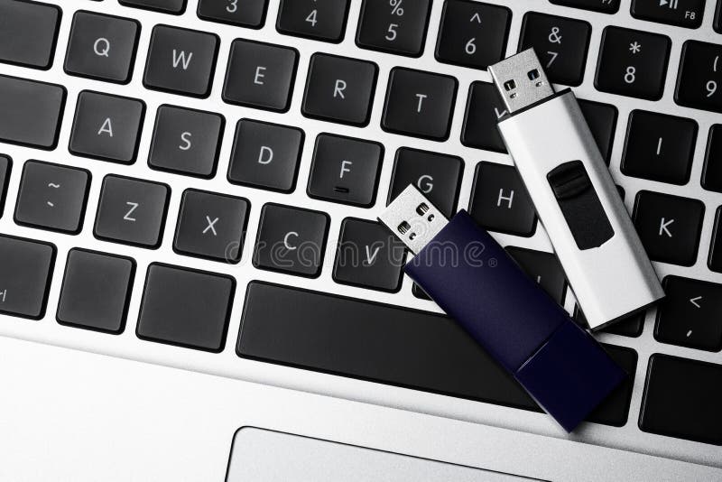 Modern Usb Flash Drives on Laptop Keyboard, Flat Lay Stock Photo