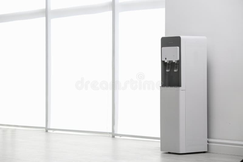 Modern water cooler near white wall indoors royalty free stock photos