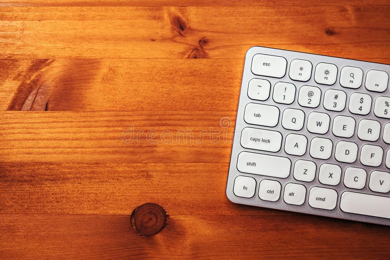 Modern White Metallic Personal Computer Keyboard on Brown Office Desk