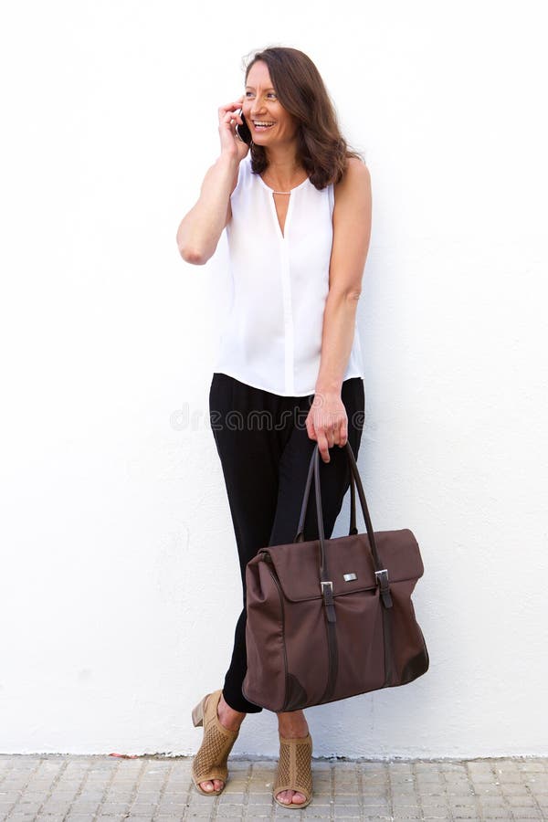 Modern woman with bag using mobile phone