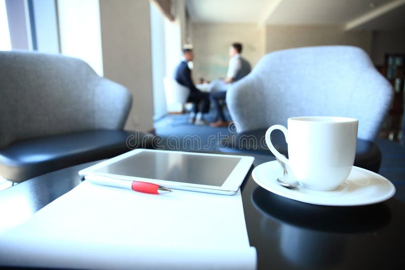 Modern workplace with digital tablet computer and mobile phone, cup of tea, pen and paper with numbers. royalty free stock image Modern workplace with digital tablet computer and mobile phone, cup of tea, pen and paper with numbers. royalty free stock image