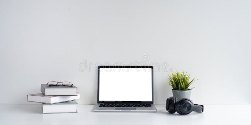Modern Workspace with Laptop, Headphones, and Books royalty free stock image