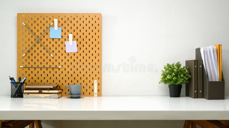 Modern workspace with pegboard, office supplies, a cup of coffee and file royalty free stock photos