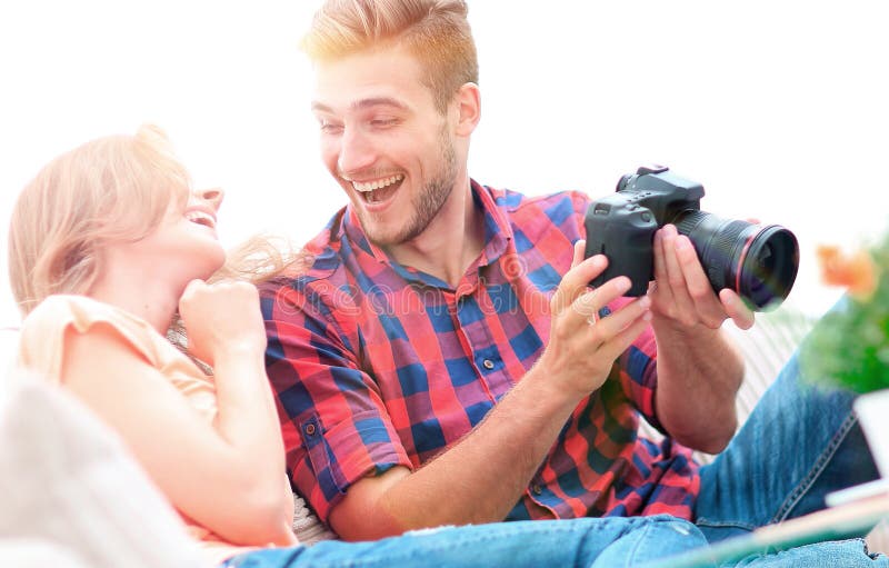 Modern young couple laughing and discussing the photos on the camera