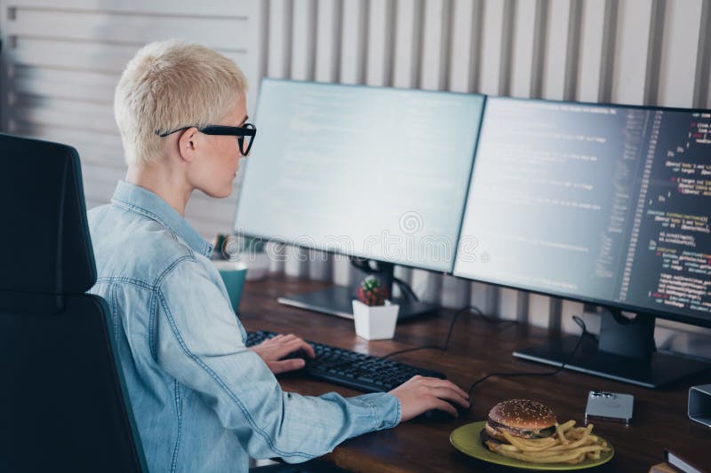 Young female programmer working in a home office setting with casual style stock image