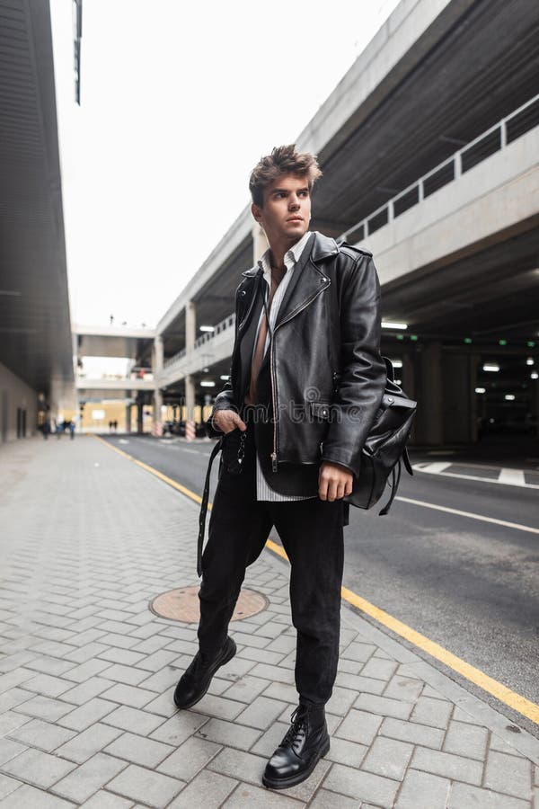 modern young hipster man trendy black casual wear poses city near road stylish urban guy model leather jacket oversize 198422722