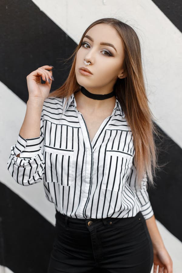Moderna Y Bonita Joven Mujer Con Pantalones Vaqueros De Moda En Una Elegante Blusa a Rayas Con Nariz Perforada Está Parada Al Aire Imagen de archivo - Imagen de camisa, hermoso: 197346833 Moderna Y Bonita Joven Mujer Con Pantalones Vaqueros De Moda En Una Elegante Blusa a Rayas Con Nariz Perforada Está Parada Al Aire Imagen de archivo - Imagen de camisa, hermoso: 197346833