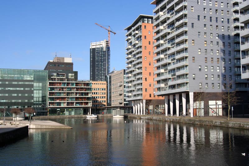 New apartment flats around a pond, office tower under construction. New apartment flats around a pond, office tower under construction