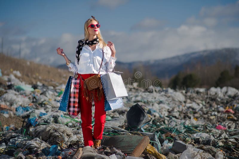 Fashionable modern woman on landfill, consumerism versus pollution concept. Fashionable modern woman on landfill, consumerism versus pollution concept.