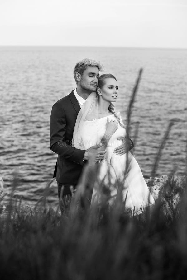 Moderne Hochzeitspaare Braut und Bräutigam Mädchen versteckt sich im Hemd eines Mannes Im Freienportrait stockfotos Moderne Hochzeitspaare Braut und Bräutigam Mädchen versteckt sich im Hemd eines Mannes Im Freienportrait stockfotos