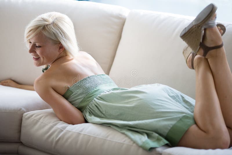 Modern lifestyle concept. Pretty woman enjoying on white couch. Modern lifestyle concept. Pretty woman enjoying on white couch