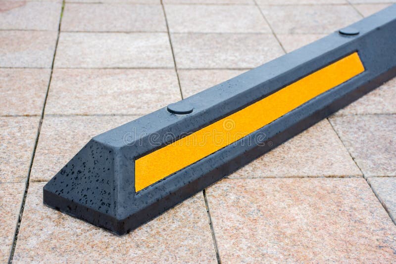 Moderne rubberbarrière voor auto's in de zomerparkeren in de straat stock foto Moderne rubberbarrière voor auto's in de zomerparkeren in de straat stock foto