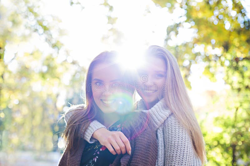 Moderne schöne junge Freundinnen, die zusammen in den Herbstparkhintergrund gehen Spa? haben und Aufstellung lizenzfreie stockbilder Moderne schöne junge Freundinnen, die zusammen in den Herbstparkhintergrund gehen Spa? haben und Aufstellung lizenzfreie stockbilder