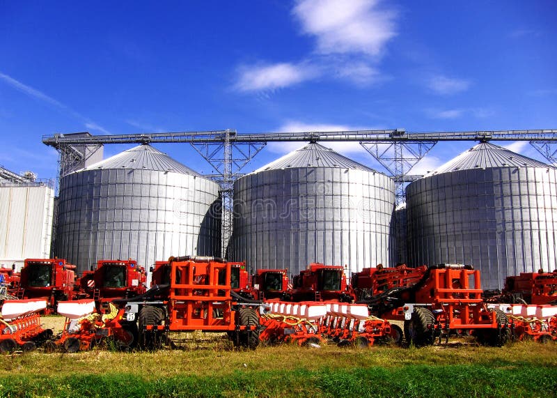 Silos and agricultural modern machinery in row. Silos and agricultural modern machinery in row