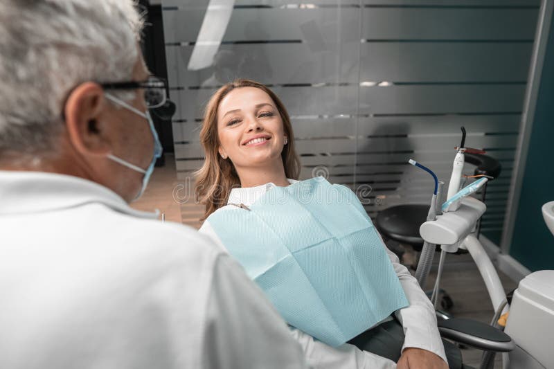 Modern dental treatment technology helps patients achieve a perfect smile. Woman smiling at dentist appointment. Teeth whitening and straightening the dentition is the way to a more confident smile. High quality photo. Modern dental treatment technology helps patients achieve a perfect smile. Woman smiling at dentist appointment. Teeth whitening and straightening the dentition is the way to a more confident smile. High quality photo