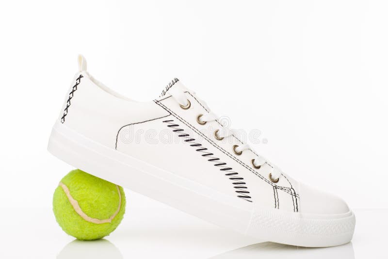 Moderne wei?e gehende Schuhe mit Tennisball auf einem wei?en Hintergrund lizenzfreies stockbild Moderne wei?e gehende Schuhe mit Tennisball auf einem wei?en Hintergrund lizenzfreies stockbild