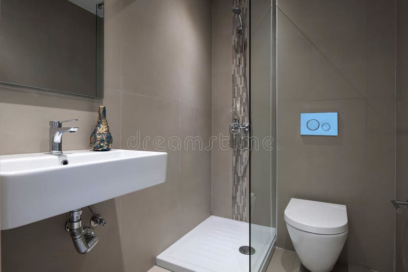 Moderner grauer Innere des kleinen Badezimmers mit Glasduschrechteckigem Spiegel hat weiße gehangene Waschbecken WC-Toilette an lizenzfreies stockfoto
