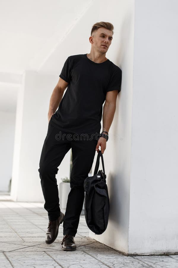 Moderner hübscher junger Mann in der schwarzen stilvollen Kleidung mit lizenzfreies stockbild Moderner hübscher junger Mann in der schwarzen stilvollen Kleidung mit lizenzfreies stockbild