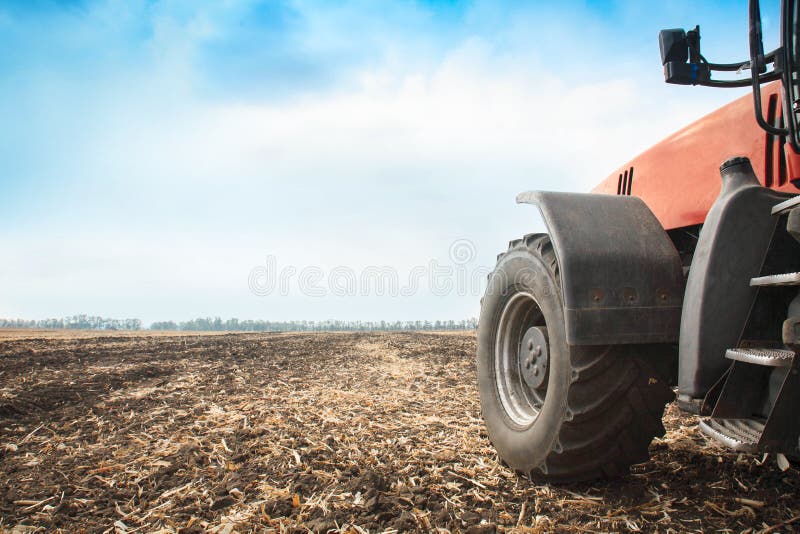 Moderner roter Traktor in der Feldnahaufnahme stockfoto Moderner roter Traktor in der Feldnahaufnahme stockfoto