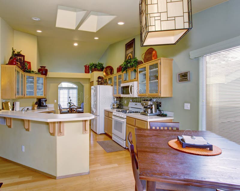 Modernized Kitchen with Light Green Walls and Hardwood Floor. Stock