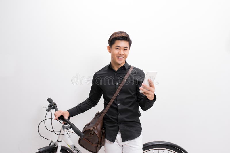 Moderno que texting alguém em sua bicicleta imagens de stock royalty free Moderno que texting alguém em sua bicicleta imagens de stock royalty free
