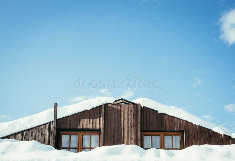 Modernt tr?hus med f?nster och sn? p? taket, bl? himmel med textutrymme royaltyfria bilder Modernt tr?hus med f?nster och sn? p? taket, bl? himmel med textutrymme royaltyfria bilder