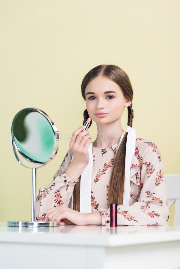 modieus de jeugdmeisje die lippenstift met spiegel toepassen stock fotografie modieus de jeugdmeisje die lippenstift met spiegel toepassen stock fotografie