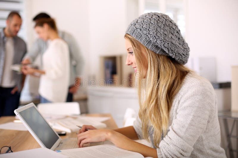 Modieus studentenmeisje die aan laptop werken stock afbeelding Modieus studentenmeisje die aan laptop werken stock afbeelding