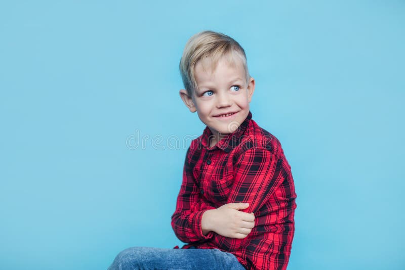 Modieus weinig jong geitje met rood overhemd Manier stijl Studioportret over blauwe achtergrond royalty-vrije stock afbeelding Modieus weinig jong geitje met rood overhemd Manier stijl Studioportret over blauwe achtergrond royalty-vrije stock afbeelding