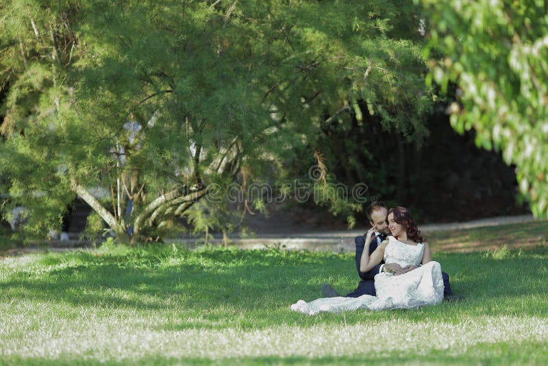 Modieuze bruid en bruidegom bij een park op hun huwelijksdag Mooi liefdeverhaal in aard, paar in liefde royalty-vrije stock fotografie Modieuze bruid en bruidegom bij een park op hun huwelijksdag Mooi liefdeverhaal in aard, paar in liefde royalty-vrije stock fotografie