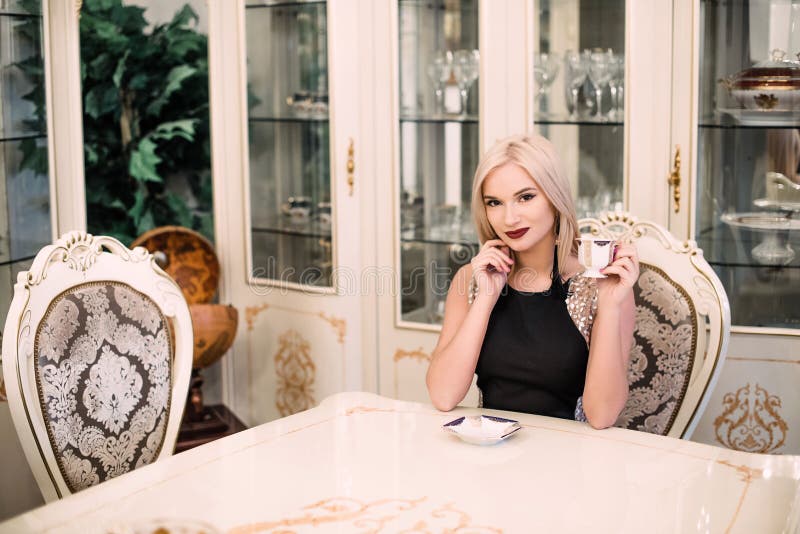 Modieuze elegante blondevrouw in schoonheids rijk binnenland, die zwarte kleding dragen royalty-vrije stock fotografie Modieuze elegante blondevrouw in schoonheids rijk binnenland, die zwarte kleding dragen royalty-vrije stock fotografie