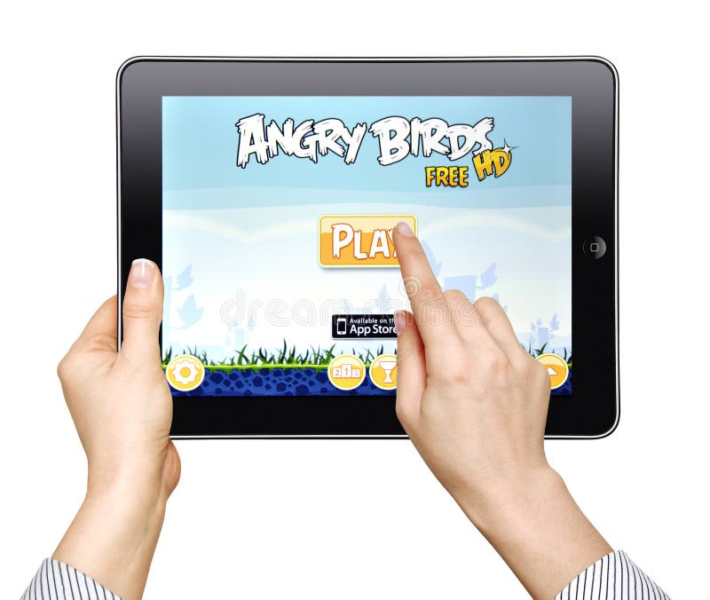 A woman play in the game Angry Birds on Apple Ipad2 isolated on white background. A woman play in the game Angry Birds on Apple Ipad2 isolated on white background