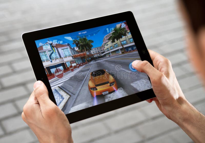 A man outdoors play in the game Asphalt 6 on Apple Ipad2. A man outdoors play in the game Asphalt 6 on Apple Ipad2.