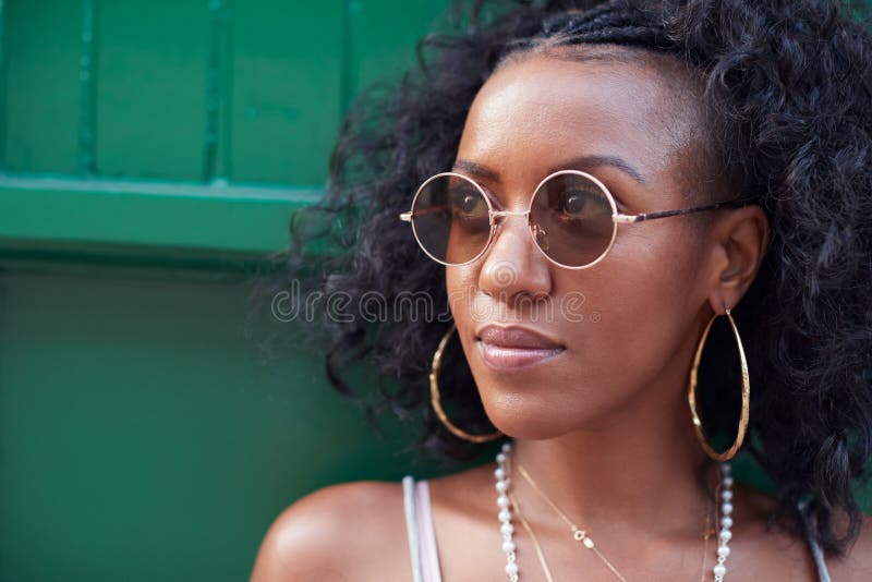 Modische junge Frau im Unterhemd und Sonnenbrille und Schmuck stockfoto Modische junge Frau im Unterhemd und Sonnenbrille und Schmuck stockfoto