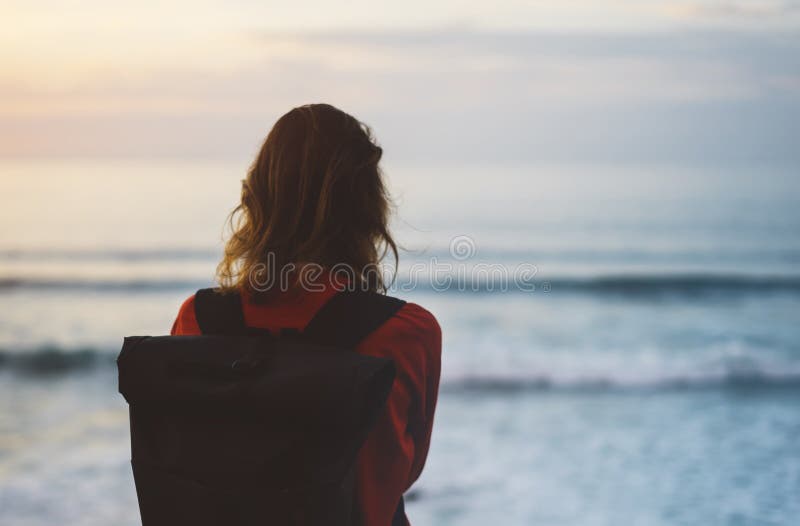 Modnisia wycieczkowicza turysta z plecaka patrzeć zadziwiający seascape zmierzch na tła błękitnym morzu, fotograf cieszy się ocea fotografia stock Modnisia wycieczkowicza turysta z plecaka patrzeć zadziwiający seascape zmierzch na tła błękitnym morzu, fotograf cieszy się ocea fotografia stock