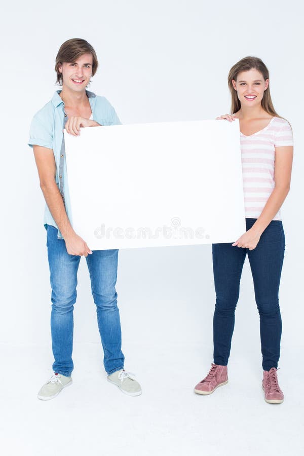 Modniś pary mienia plakat i ono uśmiecha się przy kamerą zdjęcie stock