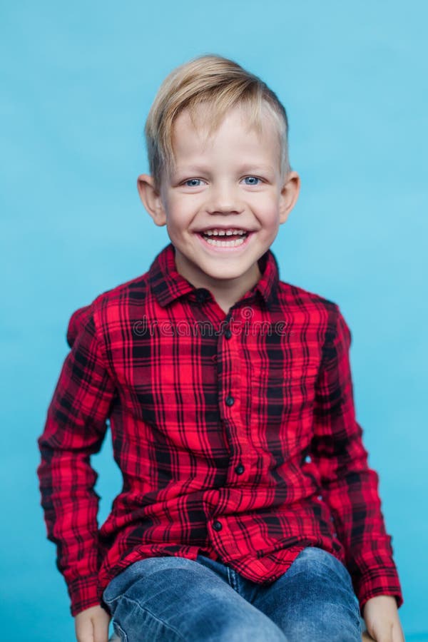 Modny małe dziecko z czerwoną koszula Moda styl Pracowniany portret nad błękitnym tłem obrazy stock Modny małe dziecko z czerwoną koszula Moda styl Pracowniany portret nad błękitnym tłem obrazy stock