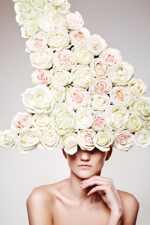 Luxury woman with a big rose hat in fashion model pose on gray background. Luxury woman with a big rose hat in fashion model pose on gray background.