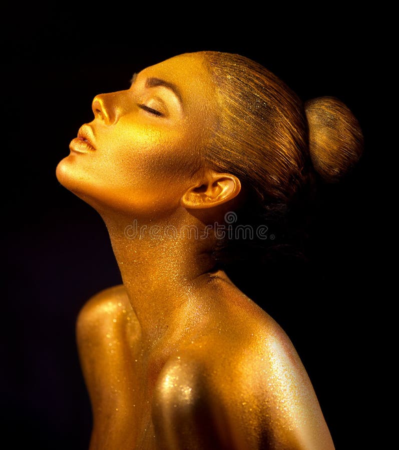 Fashion art golden skin woman portrait closeup. Gold, jewelry, accessories. Model girl with golden glamour shiny makeup. Fashion art golden skin woman portrait closeup. Gold, jewelry, accessories. Model girl with golden glamour shiny makeup