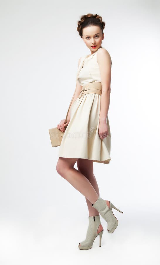 Modèle de mode mignon de femme dans la rétro pose de robe photographie stock libre de droits Modèle de mode mignon de femme dans la rétro pose de robe photographie stock libre de droits