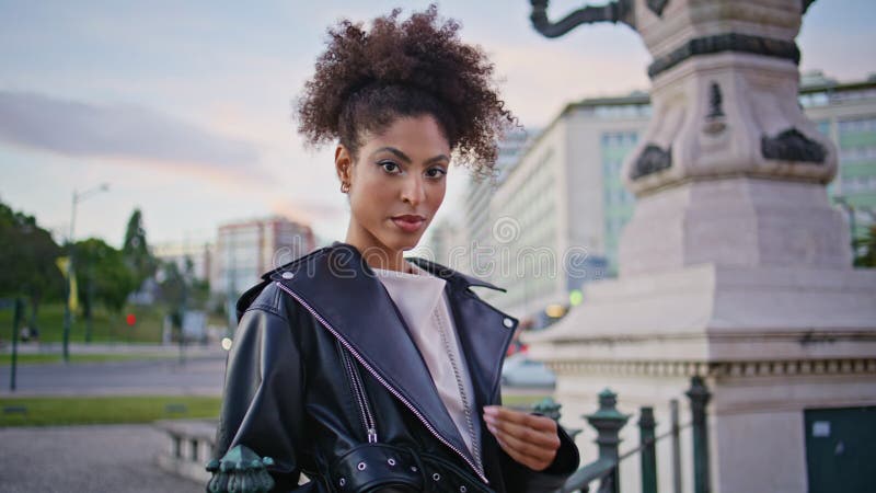 Modèle tendance place de la ville debout en closeup jacket. femme africaine confiante clips vidéos