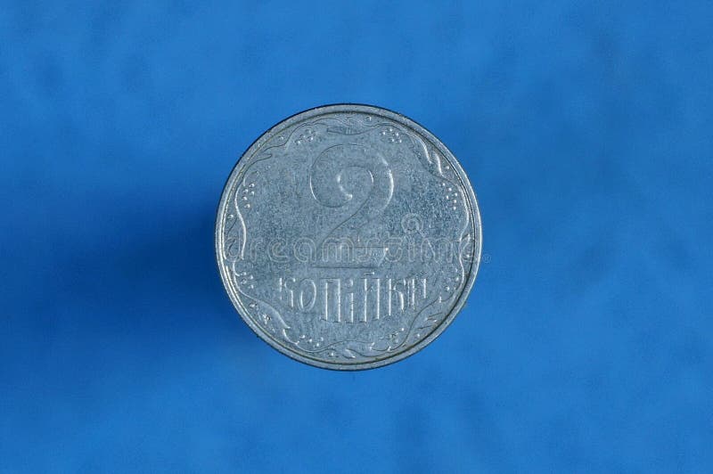 Moedas de um centavo ucranianas brancas da moeda dois em um fundo azul fotos de stock Moedas de um centavo ucranianas brancas da moeda dois em um fundo azul fotos de stock